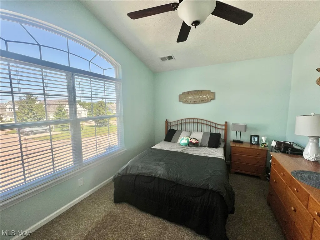 Carpeted bedroom featuring baseboards and ceiling fan