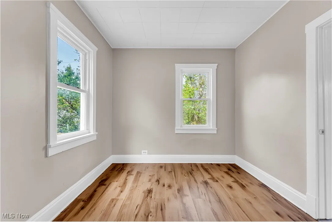 Unfurnished room featuring plenty of natural light and wood finished floors