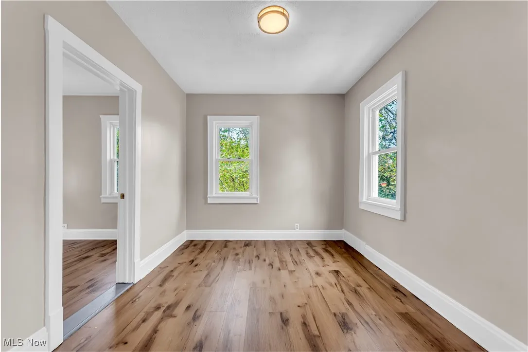 Unfurnished room with wood finished floors and baseboards