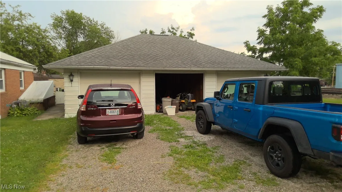 View of side of home with roof with shingles and a garage