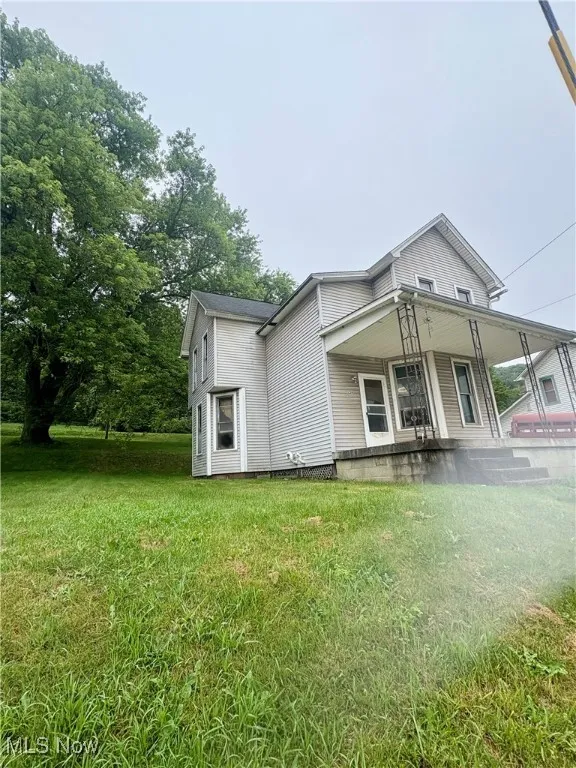 View of front facade with a front yard and a porch