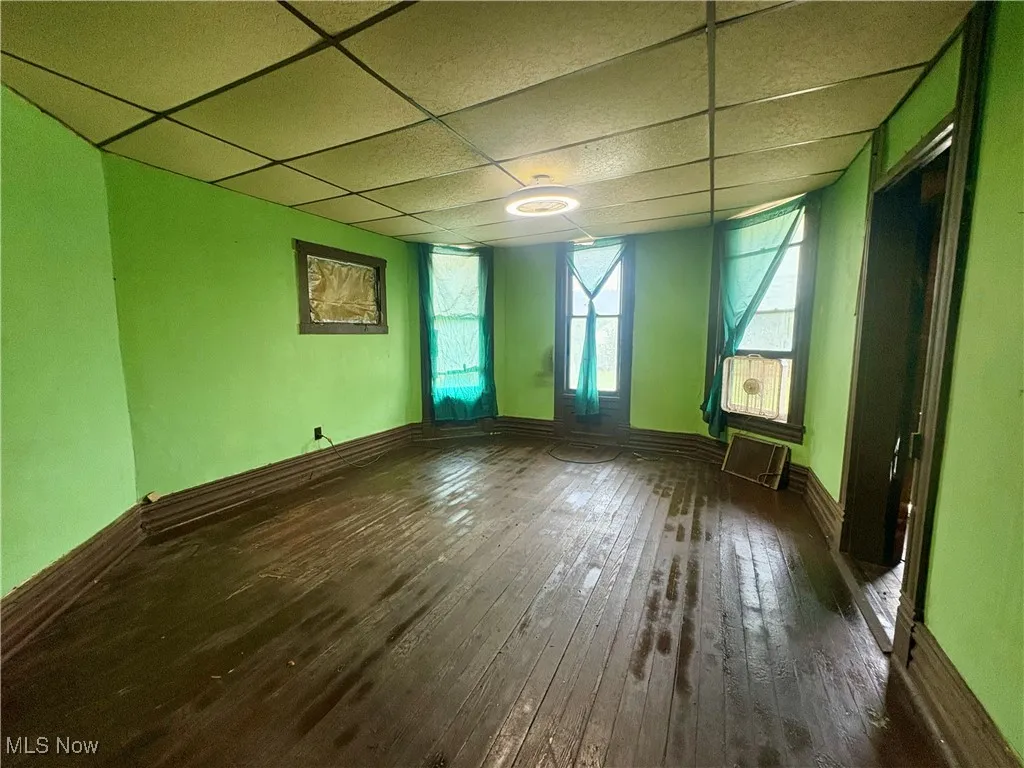 Empty room with a paneled ceiling and hardwood / wood-style floors