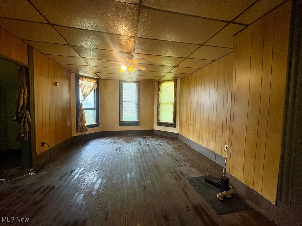 Empty room with dark wood finished floors and wooden walls