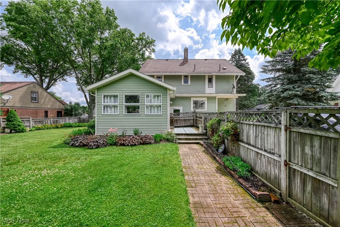This view of the Rear of property shows the large fenced yard . Brick walkway leads to the garage and a small private patio area.
