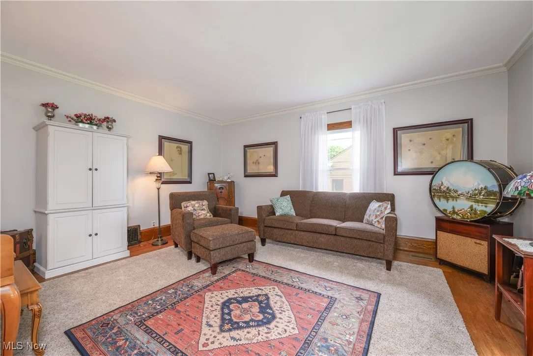 Living room with crown molding and oversized baseboards.