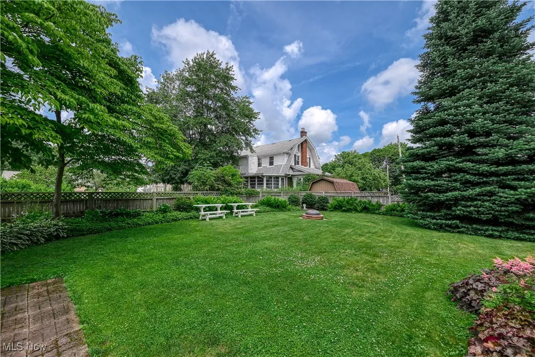 View of backyard from the deck. Lush landscaping surrounds the house and fully fenced yard.