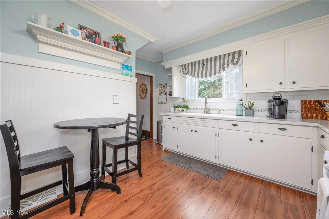 Kitchen with crown molding, tile backsplash, LVT flooring