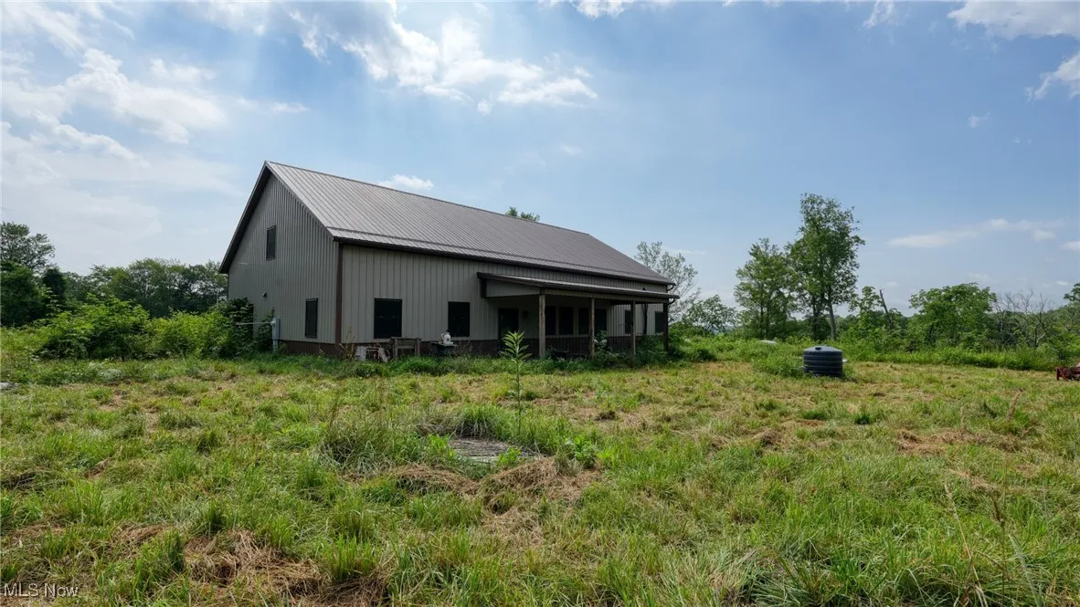 Rear view of house featuring a metal roof, an outdoor structure, and an outbuilding