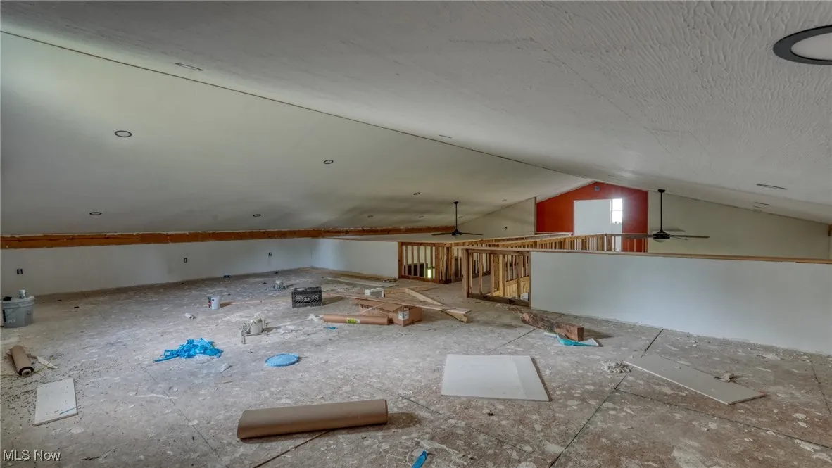 Additional living space with a ceiling fan and lofted ceiling