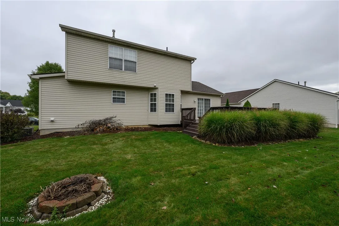 Rear view of property with a wooden deck and a lawn