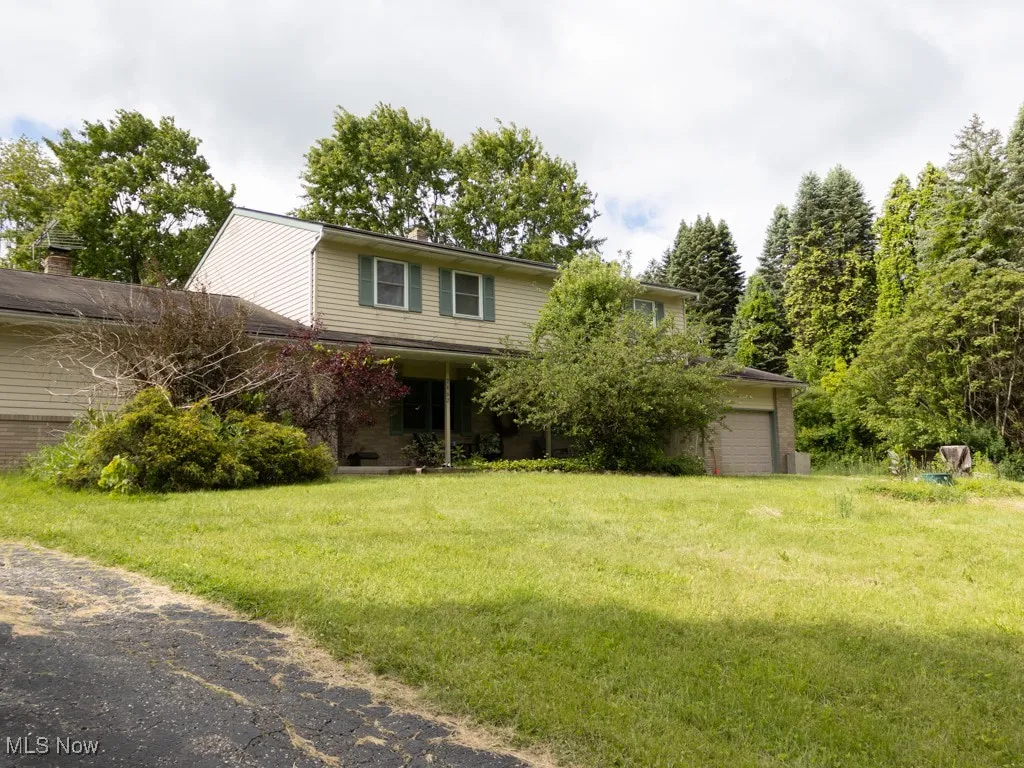 View of front of house with brick siding, a garage, and a front yard