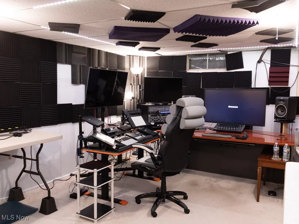 Office with a paneled ceiling and light carpet