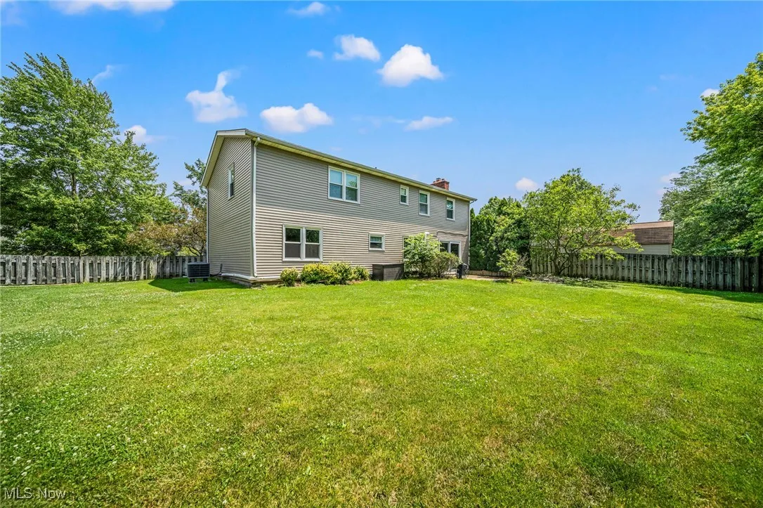 Rear view of house featuring a fenced backyard and a chimney