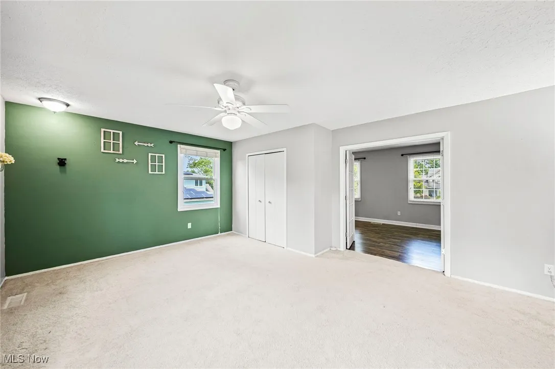 Unfurnished bedroom with carpet flooring, a closet, and a ceiling fan