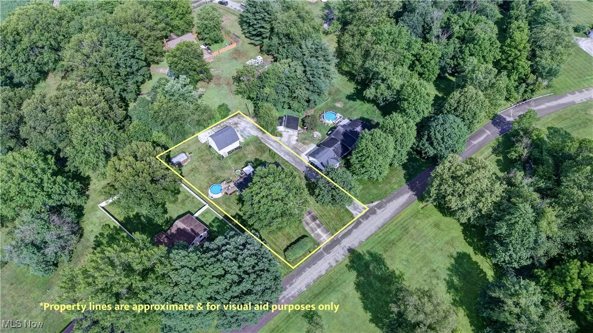Aerial view of property and surrounding area featuring property parcel outlined