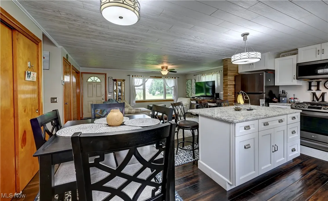 Kitchen featuring appliances with stainless steel finishes, dark wood-style floors, and a center island