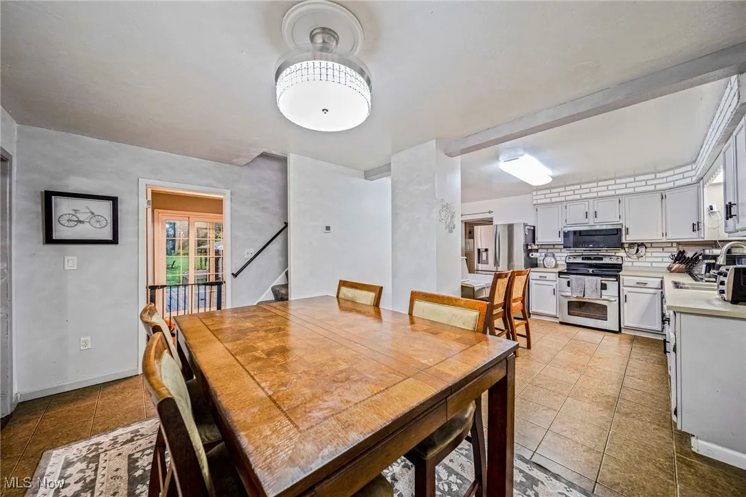 Dining area featuring light tile patterned flooring and stairway
