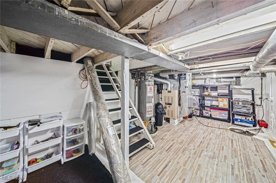 Unfinished basement featuring water heater and heating unit