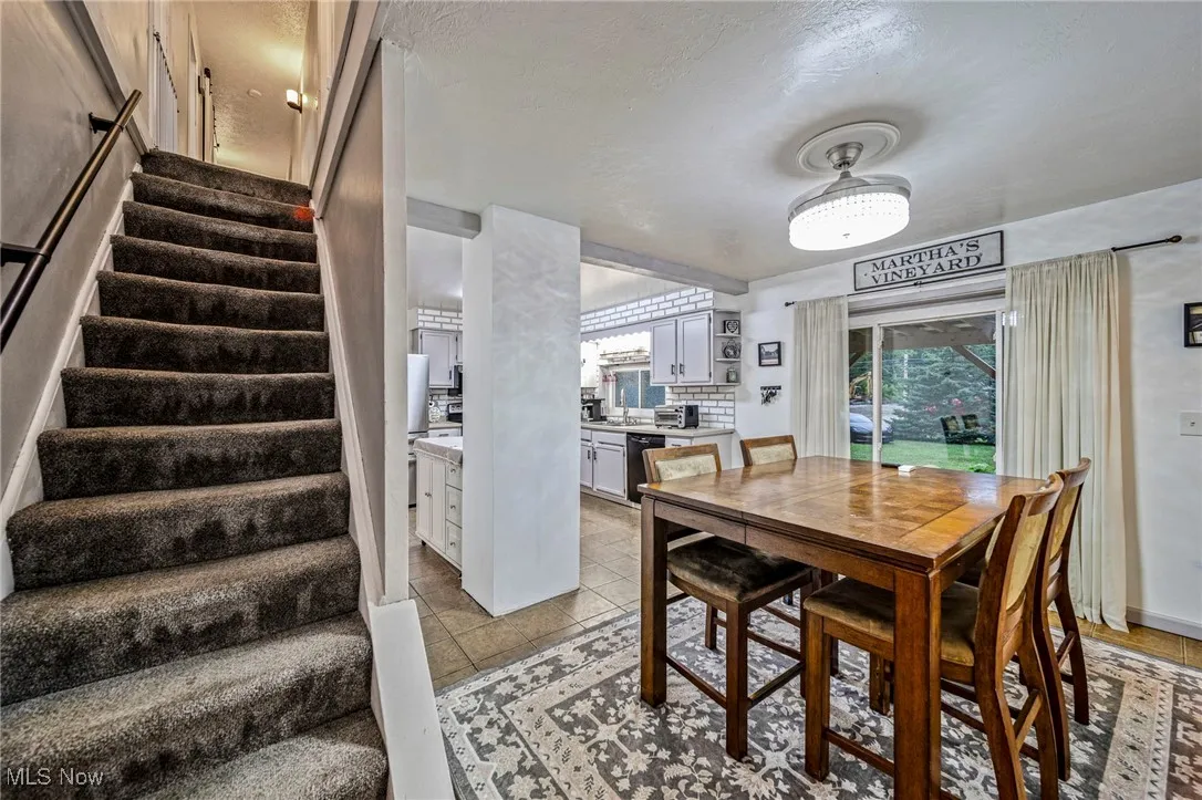 Dining area featuring stairway and light tile patterned floors