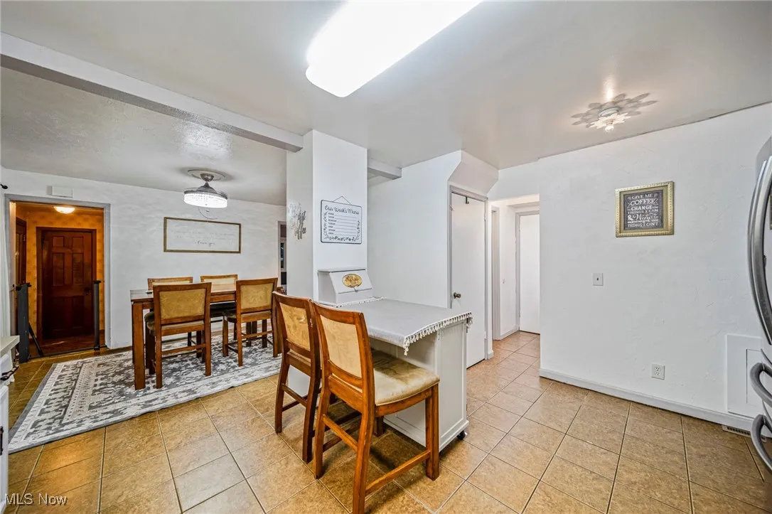 Dining space with light tile patterned floors and baseboards