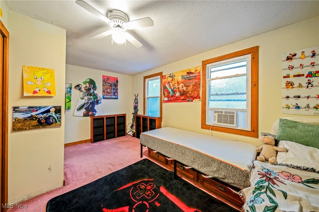 Bedroom with carpet flooring, cooling unit, and a ceiling fan
