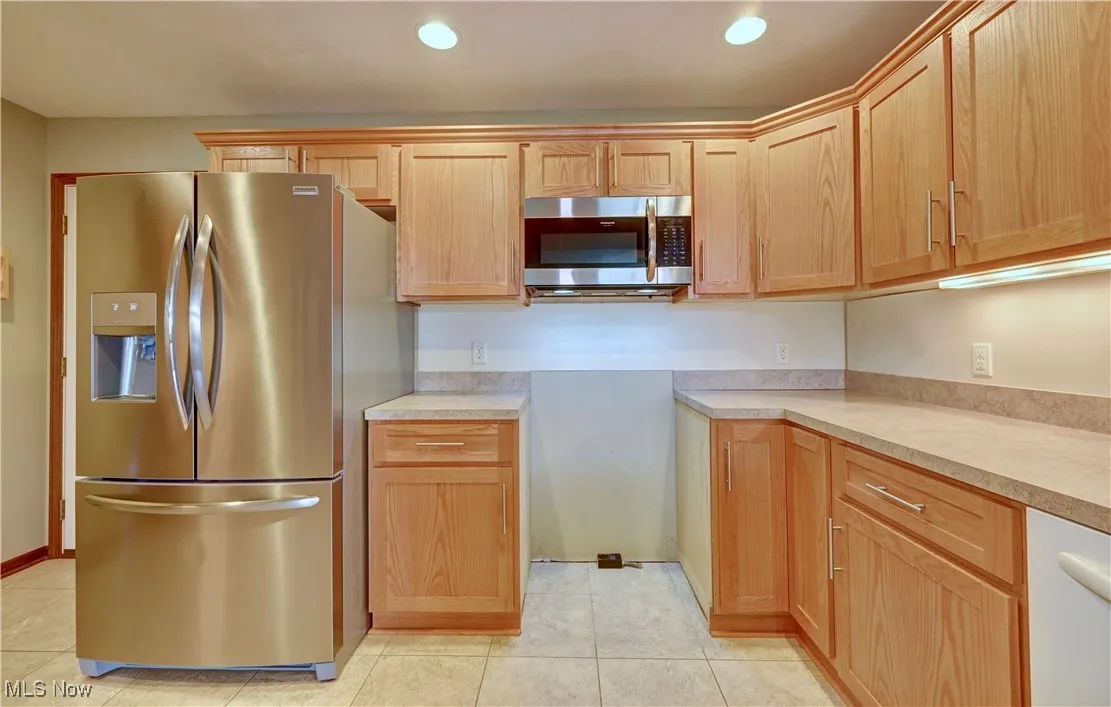 Kitchen featuring appliances with stainless steel finishes, light countertops, light tile patterned floors, and recessed lighting