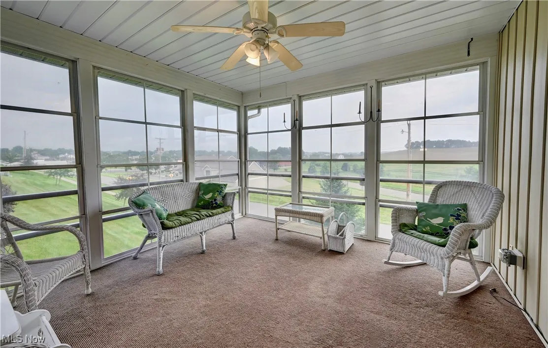 Sunroom featuring ceiling fan, healthy amount of natural light, and a water view