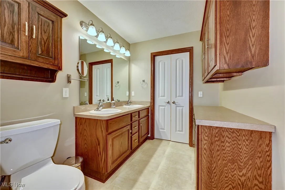 Full bathroom featuring double vanity and toilet