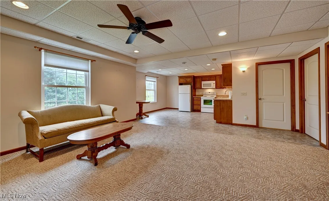 Living room with a ceiling fan, light colored carpet, and recessed lighting