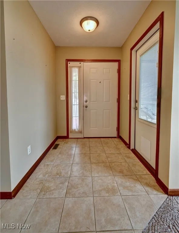 Foyer entrance featuring plenty of natural light and light tile patterned floors