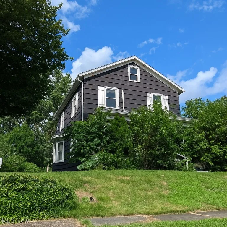 View of side of home with a lawn