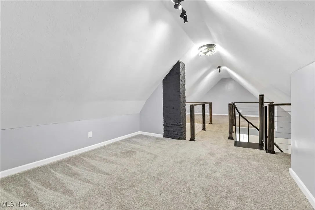 Bonus room with carpet flooring and lofted ceiling