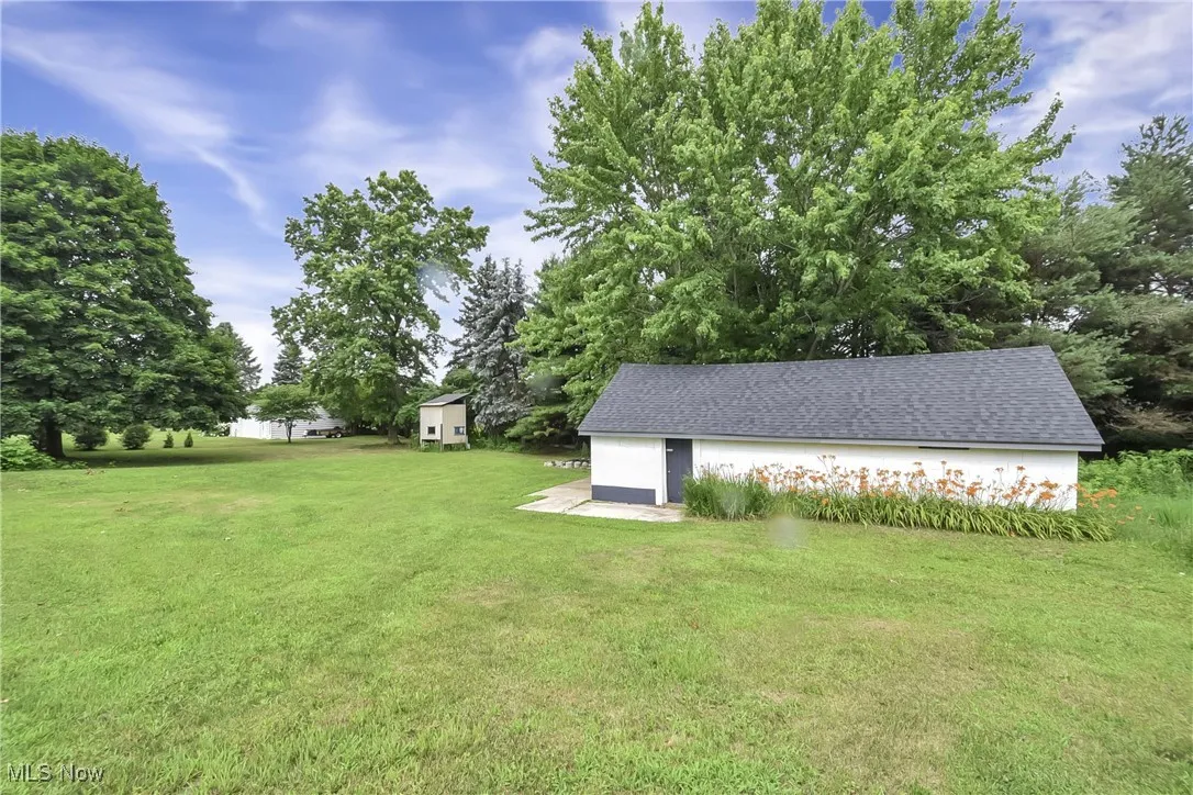 View of grassy yard with a garage
