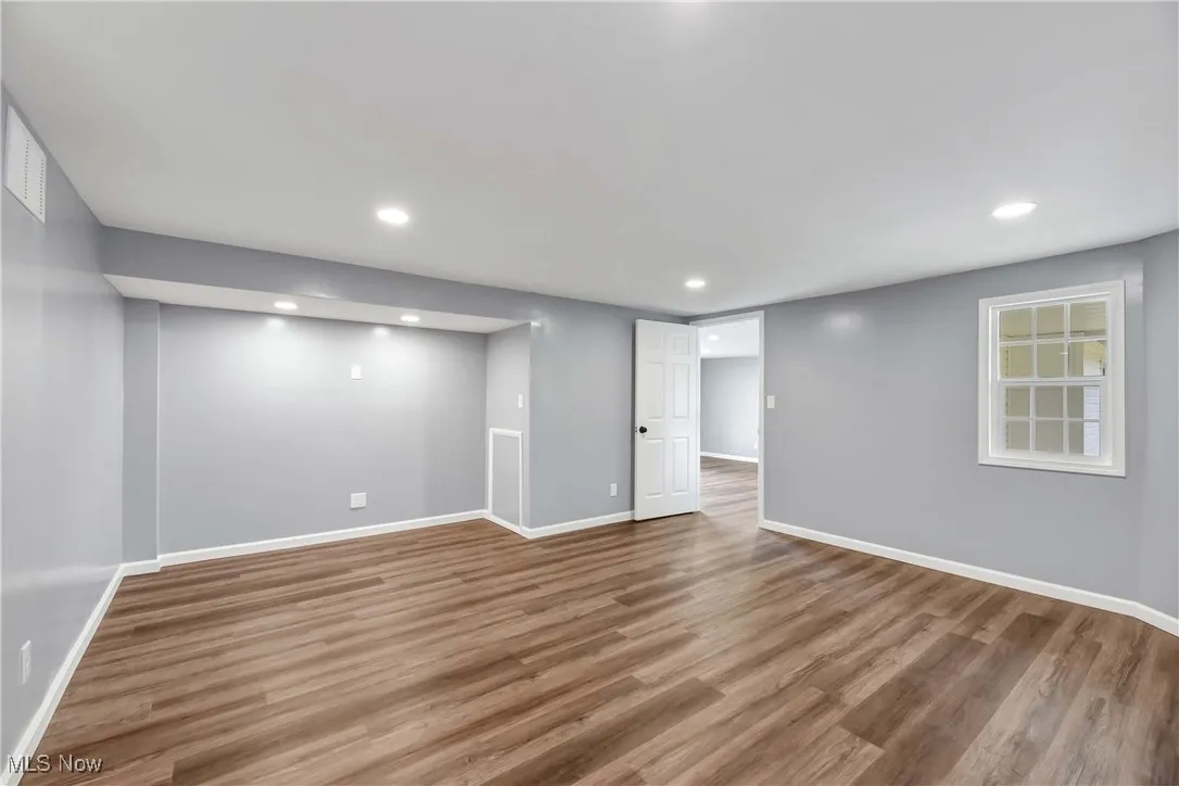 Finished basement with wood finished floors and recessed lighting