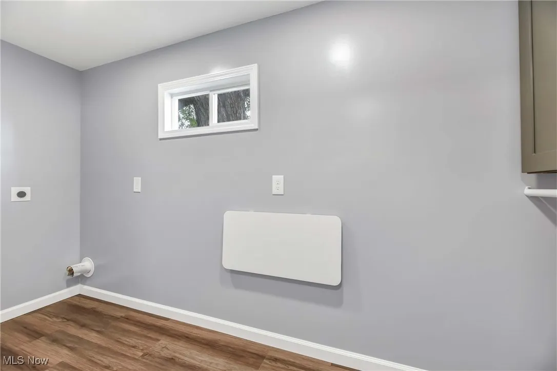 Laundry room featuring electric dryer hookup and wood finished floors