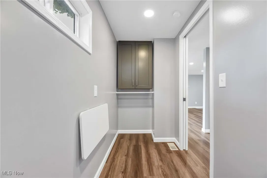 Corridor with wood finished floors and recessed lighting