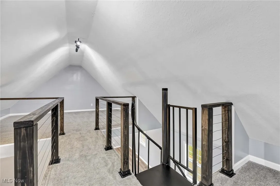 Bonus room featuring lofted ceiling and carpet
