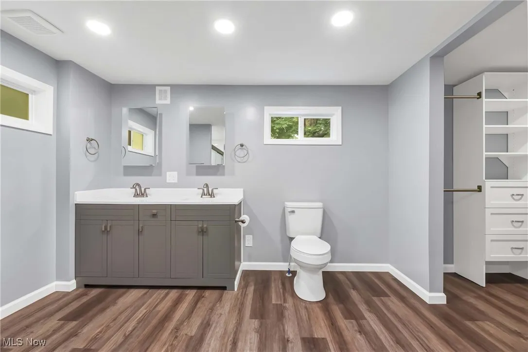 Bathroom featuring wood finished floors, double vanity, and recessed lighting
