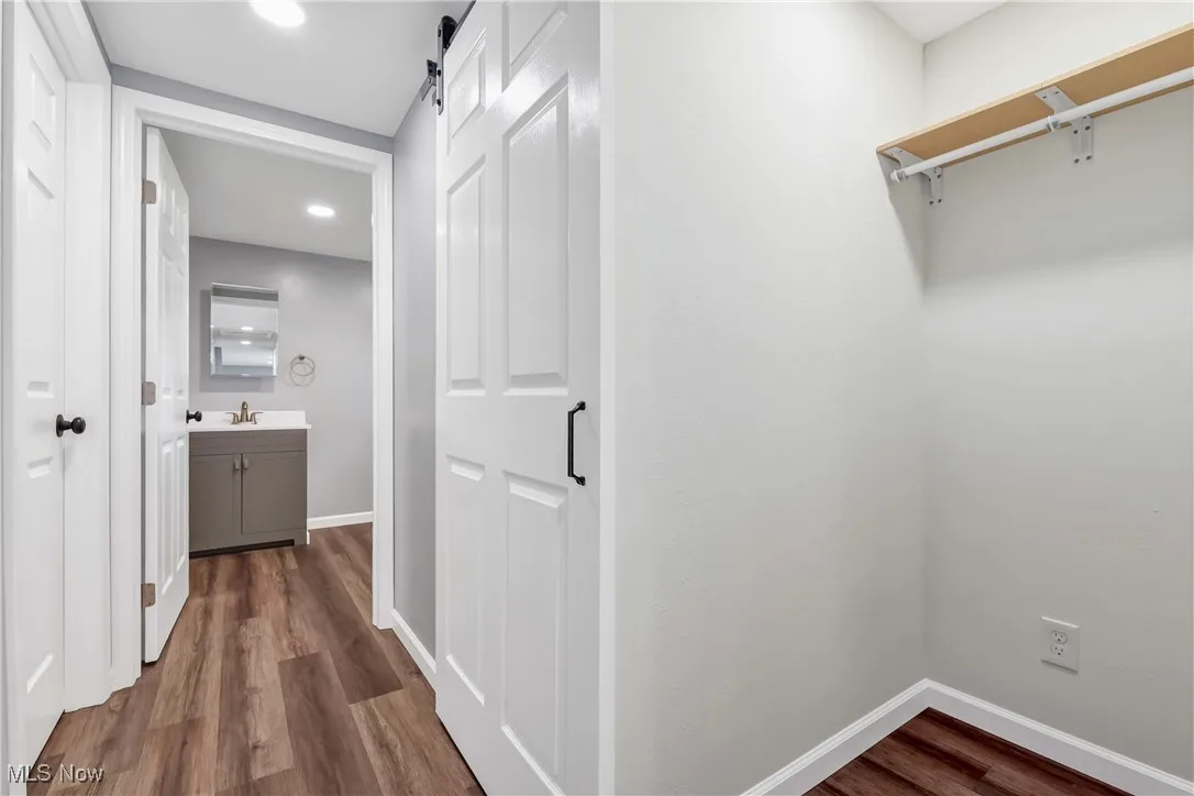 Hallway with dark wood finished floors and recessed lighting