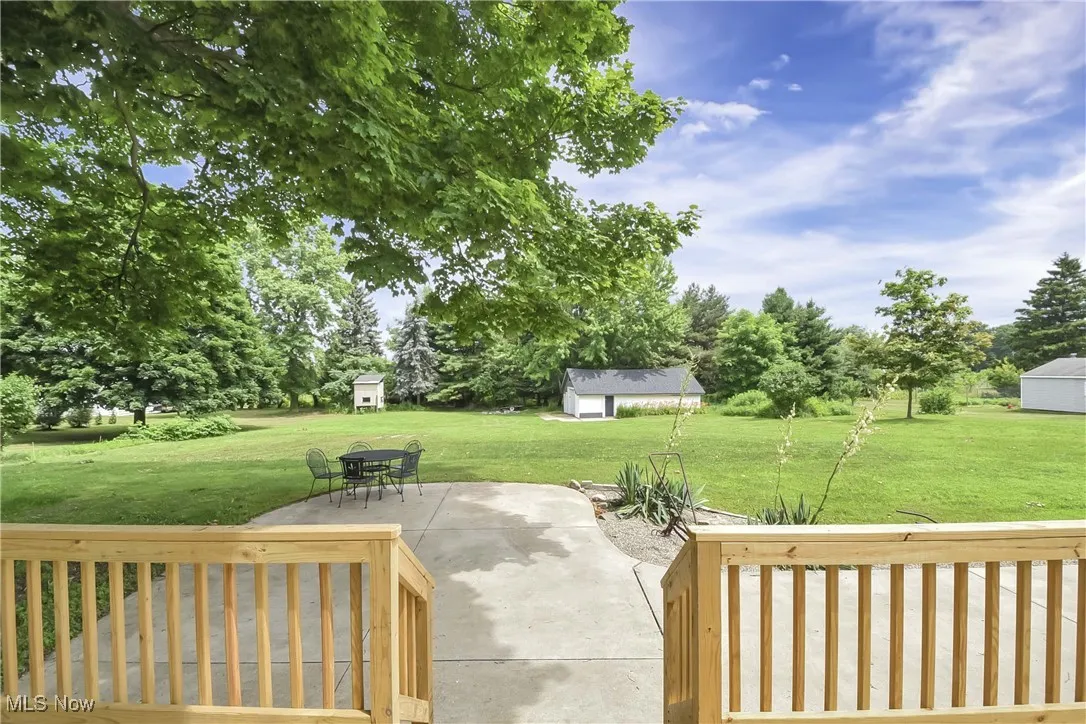 View of patio / terrace featuring an outdoor structure and view of wooded area