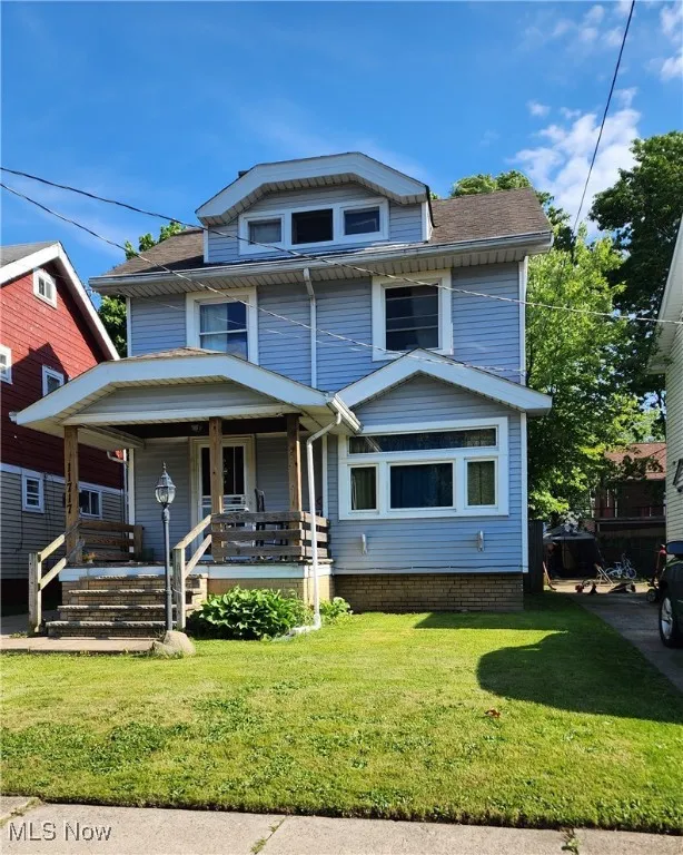 Traditional style home featuring a porch and a front yard