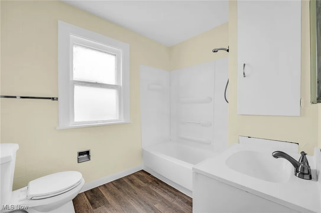 Full bathroom featuring wood finished floors, vanity, and shower / bath combination