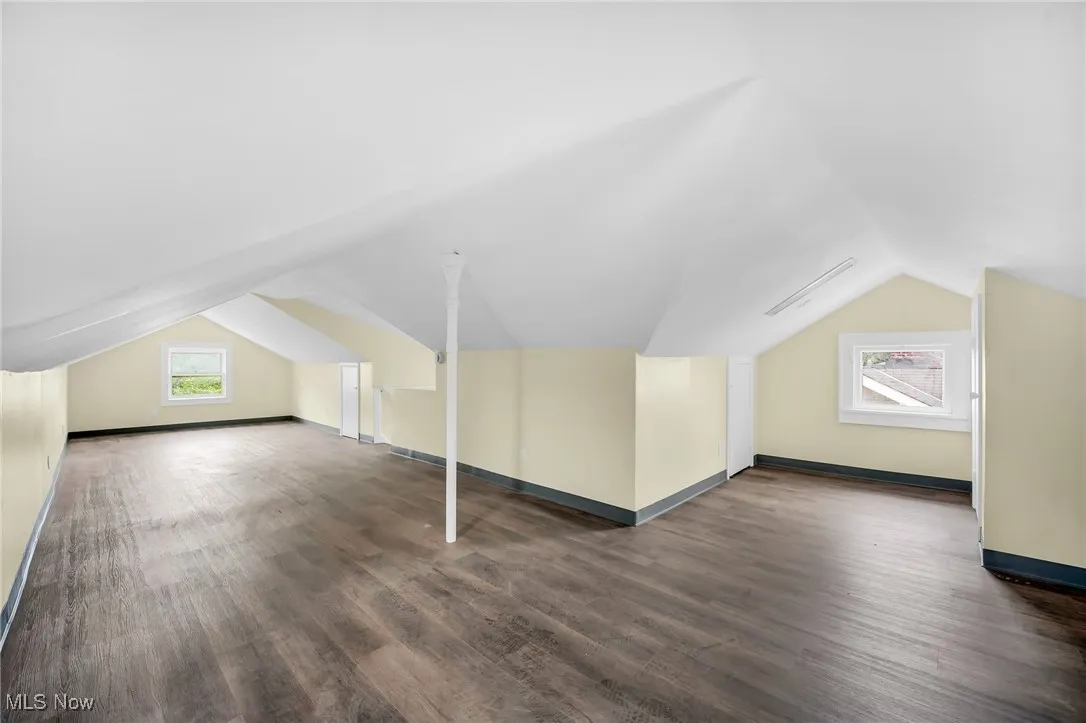 Additional living space featuring vaulted ceiling, wood finished floors, and baseboard heating