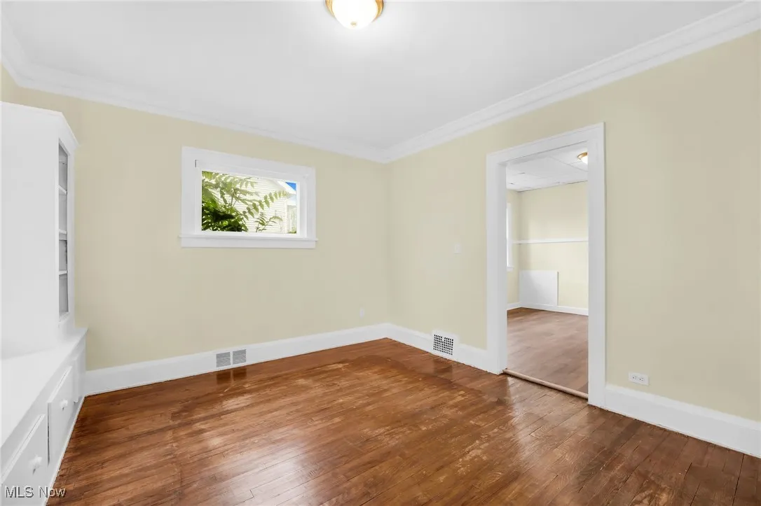 Unfurnished room featuring wood-type flooring and ornamental molding