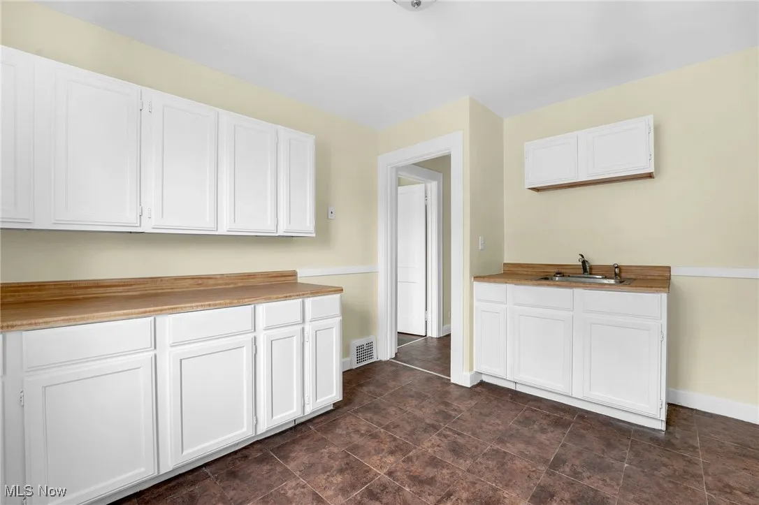 Kitchen featuring white cabinetry and light countertops