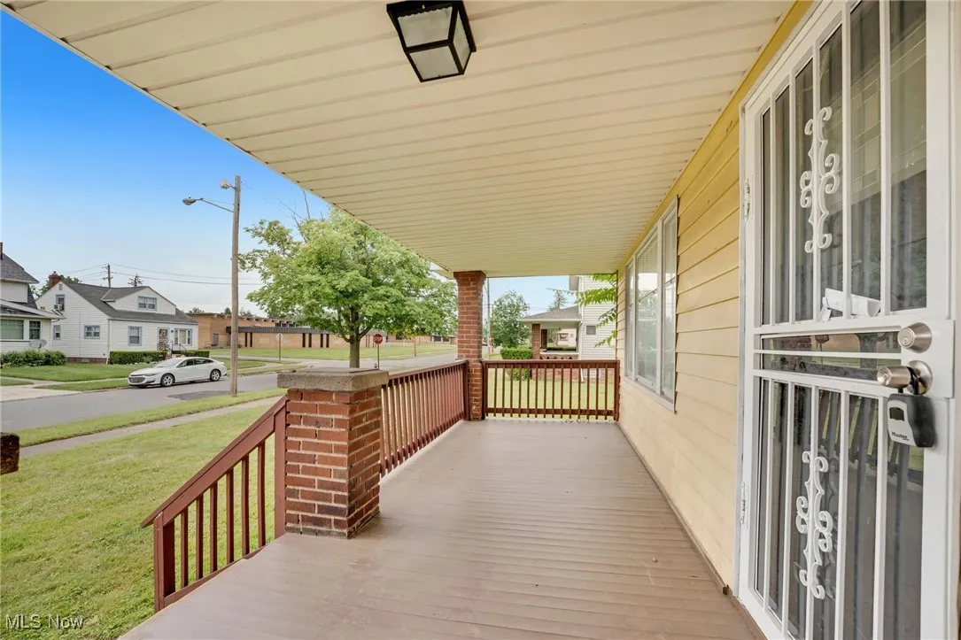 Wooden porch featuring a lawn and a residential view