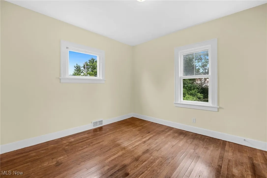 Unfurnished room featuring plenty of natural light and hardwood / wood-style flooring