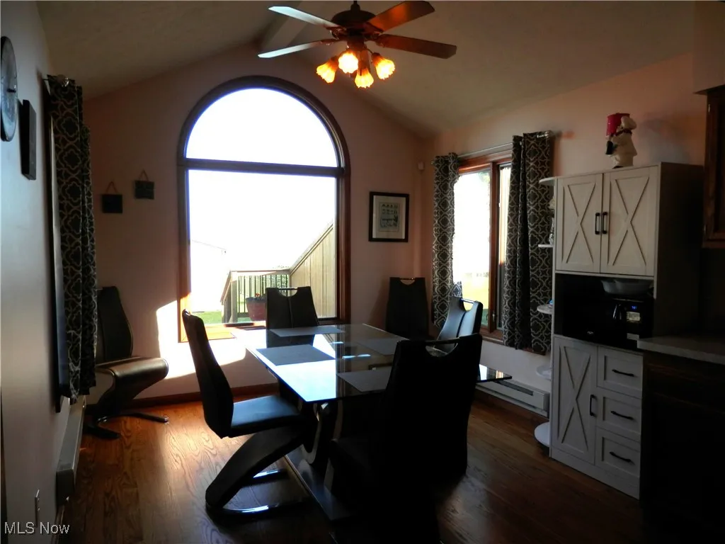 Dine in kitchen area featuring ceiling fan, vaulted ceiling, and hardwood floors
