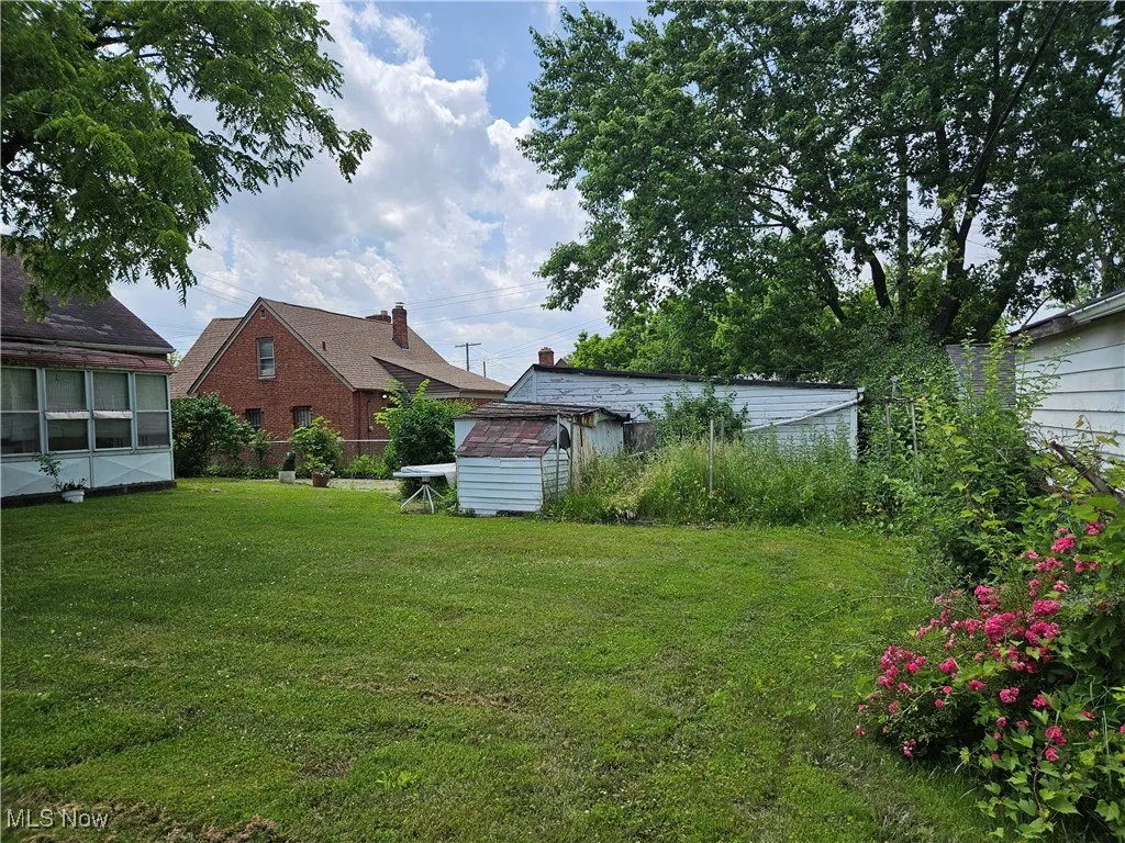 View of green lawn featuring a storage unit