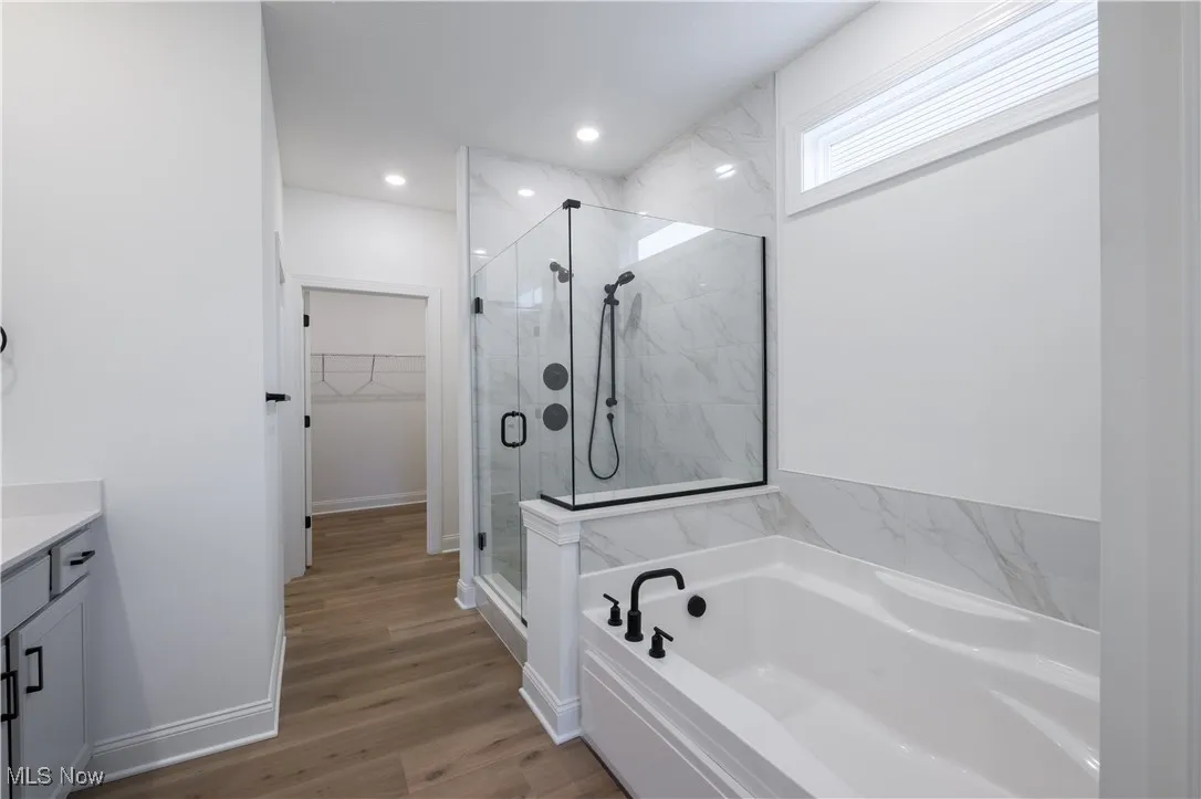Tiled walk-in shower and separate soaking tub.